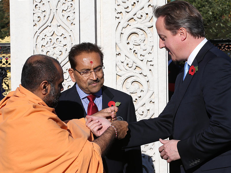 British Prime Minister David Cameron is greeted traditionally on arrival at the London Mandir