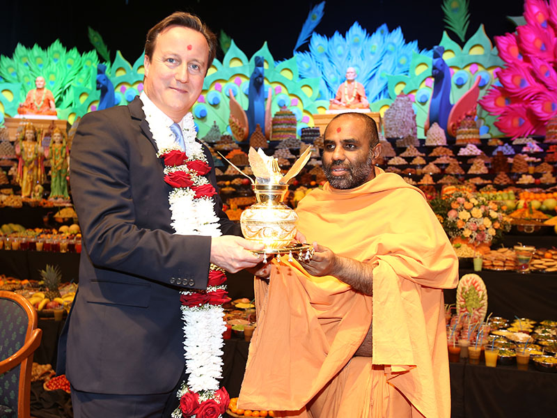 Satyavrat Swami presents a kalash to British Prime Minister David Cameron 