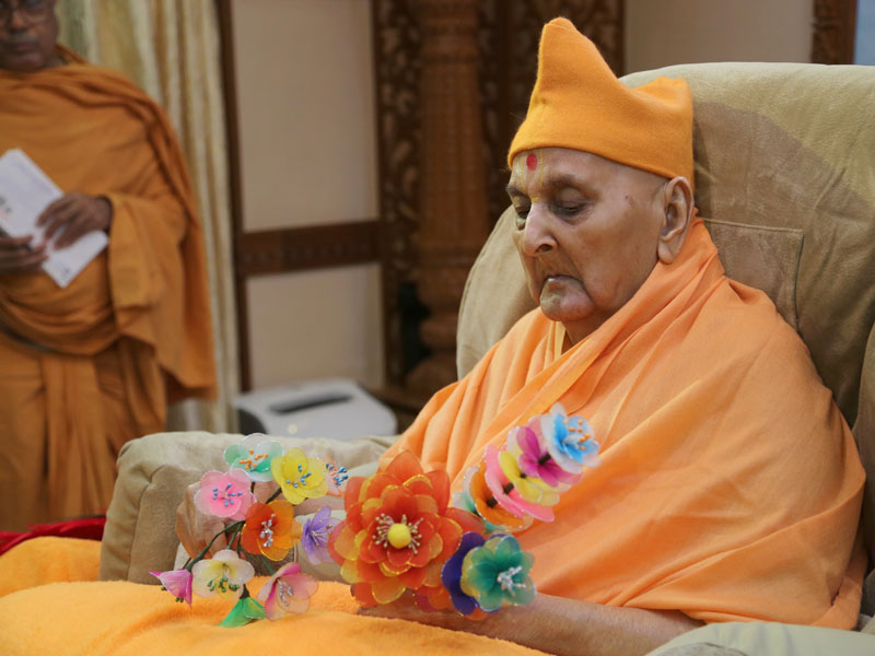 Swamishri sanctifies a flower chhadi