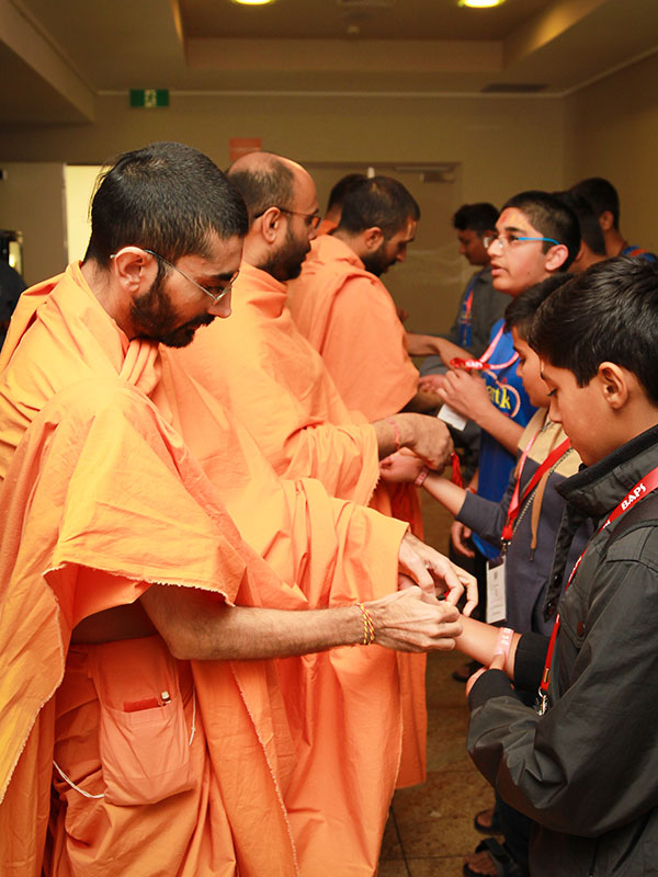 Sadhus tie a nadachhadi to delegates arriving for the morning session