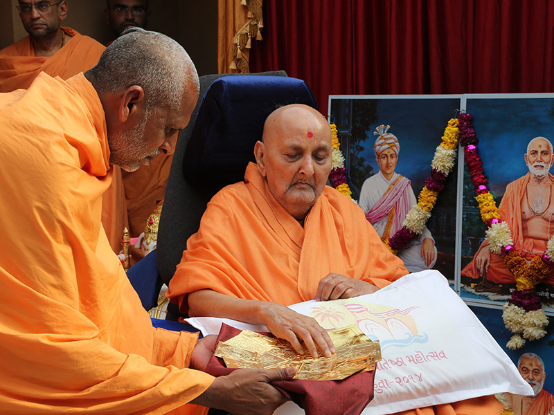 Swamishri sanctifies yantras to placed beneath the murtis at Mahuva Mandir