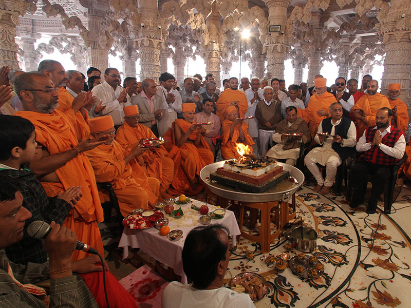 Senior sadhus and devotees performs arti of the Vastu - Mandir Pravesh rituals