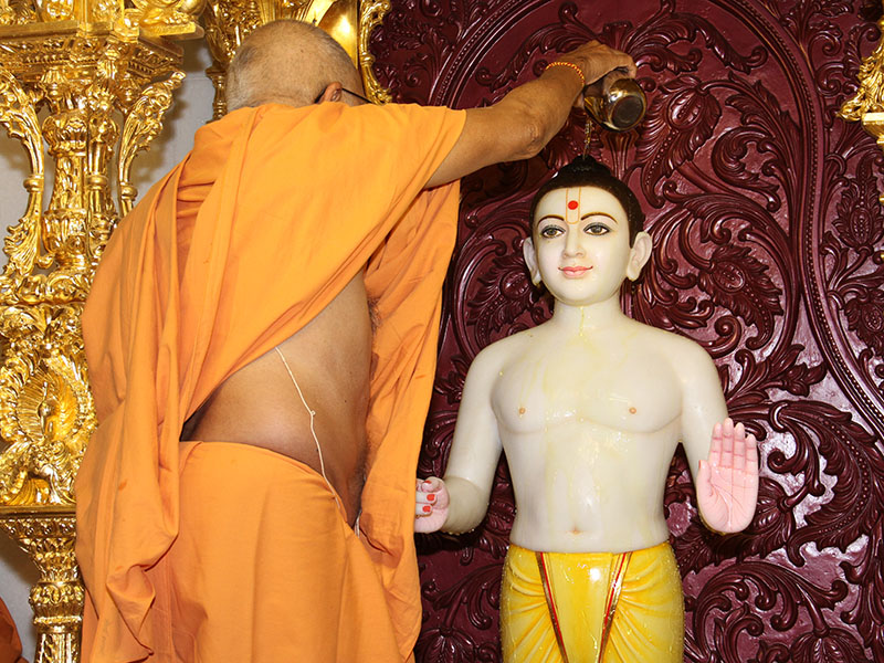 Abhishek of murtis as part of murti-pratishtha rituals being performed by Pujya Bhaktipriya Swami (Pujya Kothari Swami)