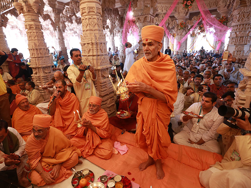 Pujya Mahant Swami and devotees perform pratishtha arti