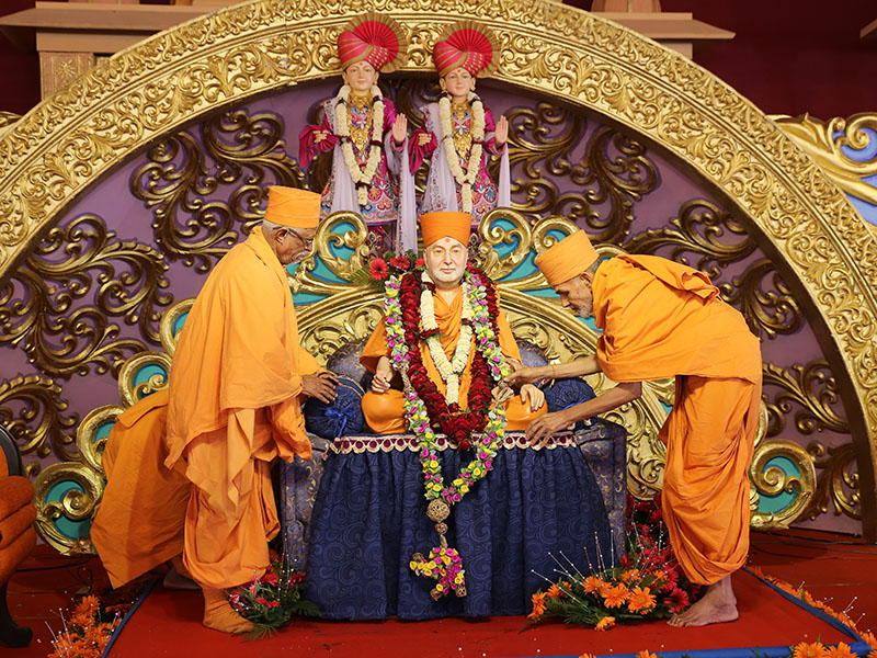 Pujya Mahant Swami and Pujya Doctor Swami honor Swamishri's murti with garlands