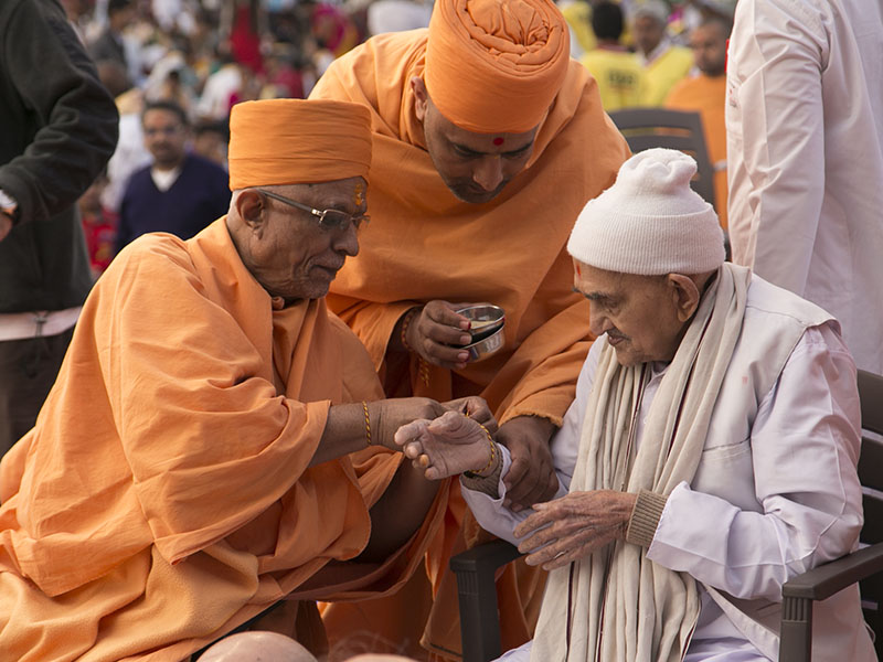 Pujya Doctor Swami ties nadachhadi to a senior devotee