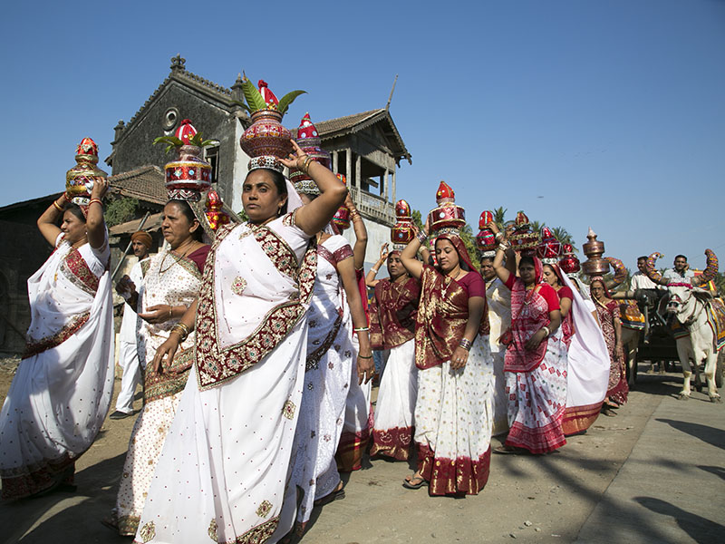 Women carrying 'kalash' participate in the procession