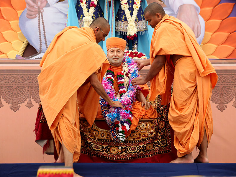Sadhus honor Swamishri's murti with a garland