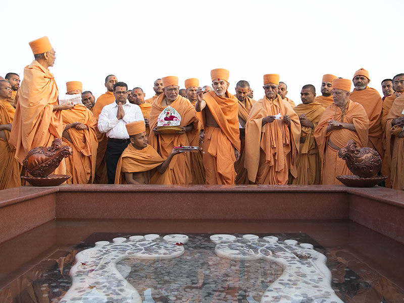 Pujya Mahant Swami, Pujya Doctor Swami, Pujya Kothari Swami, Pujya Tyagvallabh Swami perform pujan of holy charnarvind of Bhagwan Swaminarayan in the mandir grounds