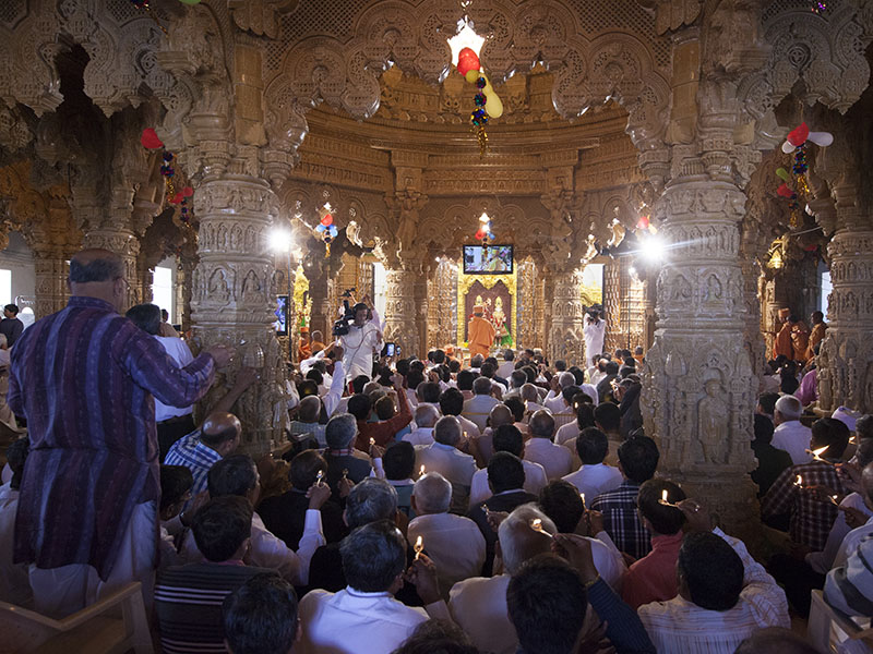 Pujya Mahant Swami and devotees perform pratishtha arti