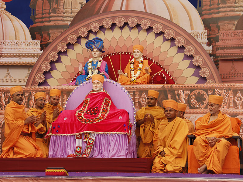 Sadhus serving at Jamnagar Mandir honor Swamishri's murti with a garland