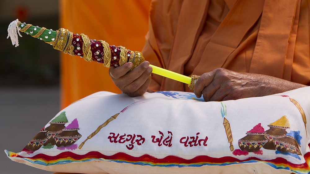 Swamishri holds a 'pichkari' for spraying colored water