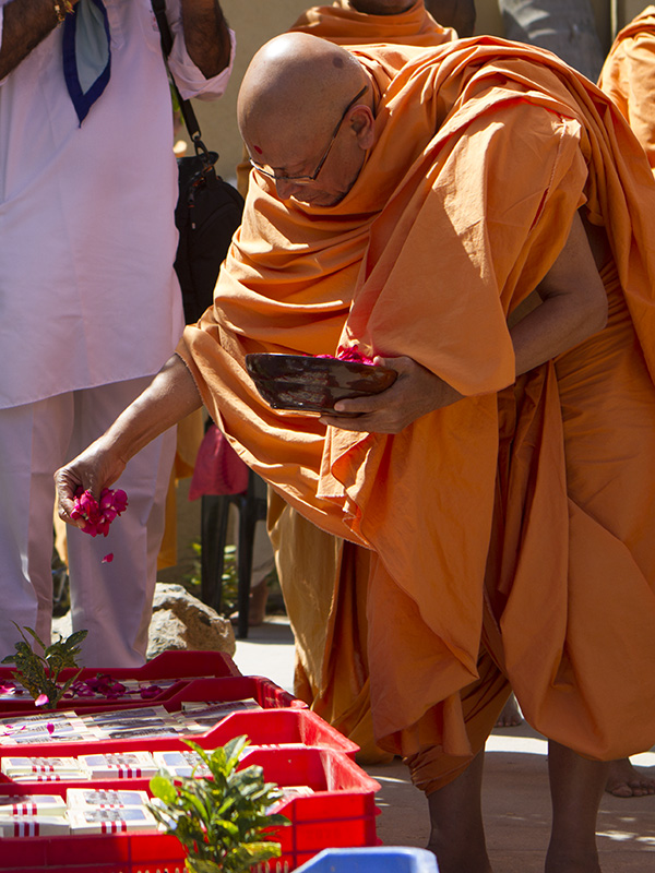 Pujya Tyagvallabh Swami showers sanctified flower petals on prasad boxes