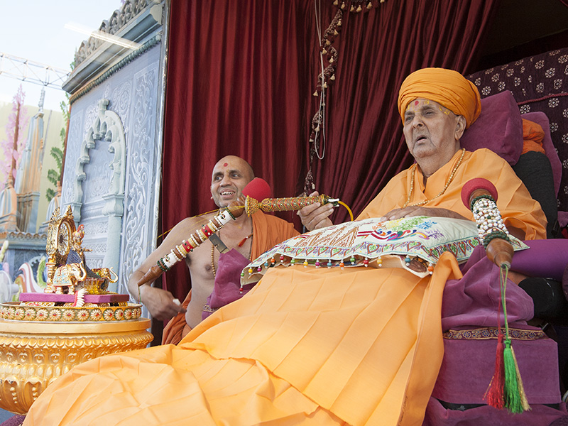 Swamishri arrives on stage and sprays colored water on Shri Harikrishna Maharaj