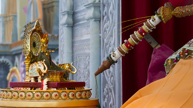 Swamishri sprays colored water on Shri Harikrishna Maharaj