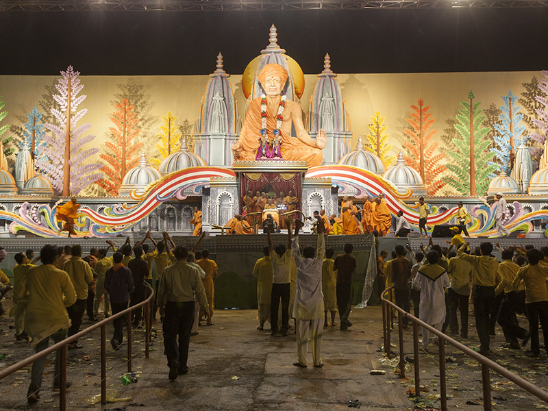 Swamishri arrives back on stage after the Pushpadolotsav sabha
