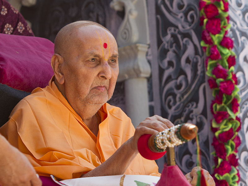 Swamishri starts spraying sanctified colored water on sadhus