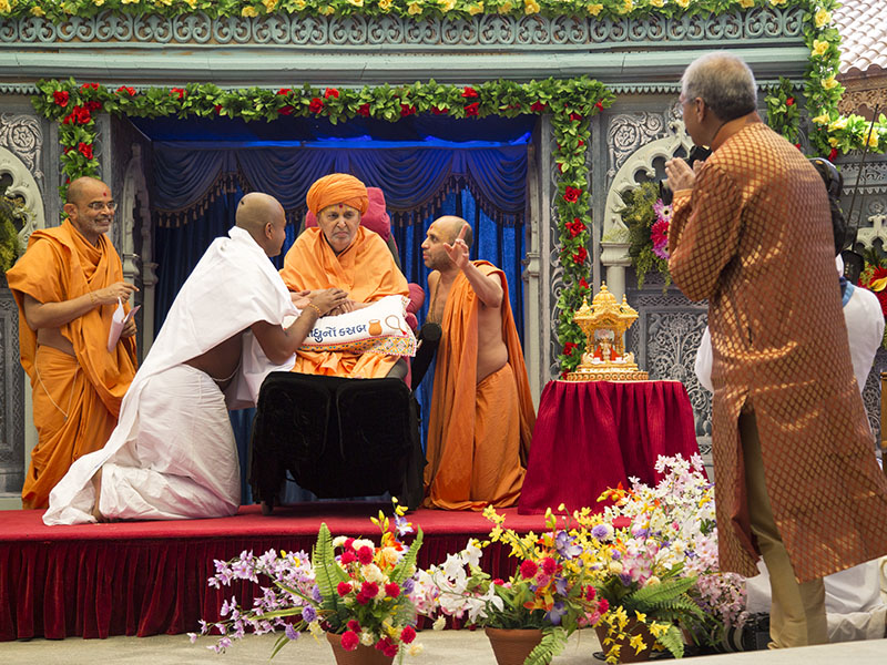 Swamishri gives diksha mantra to newly initiated parshads and blesses the parshads and their families