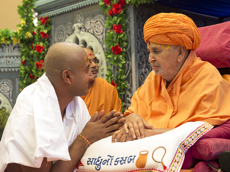 Swamishri gives diksha mantra to newly initiated parshads and blesses them
