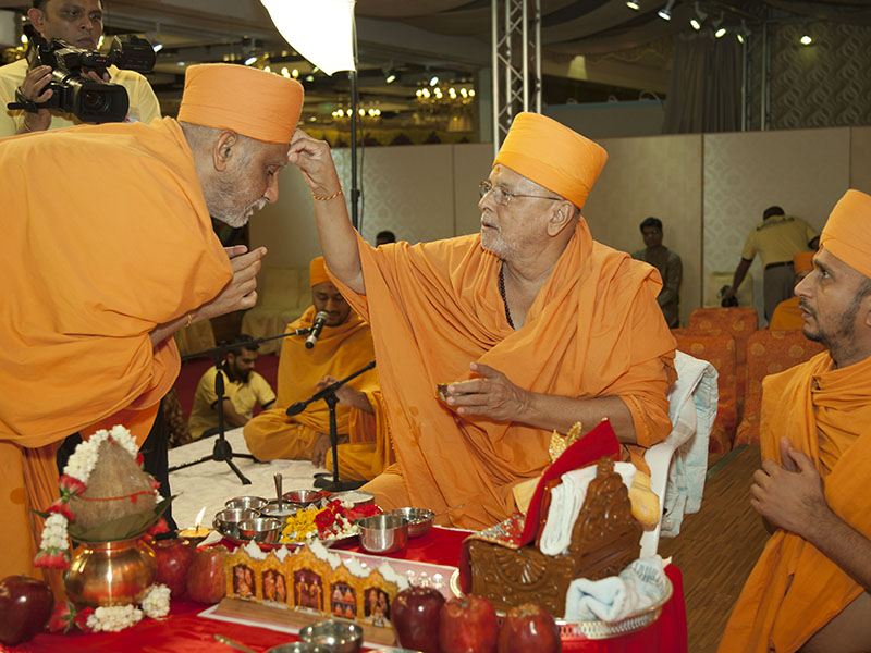 Pujya Ishwarcharan Swami applies chandlo to Atmaswarup Swami