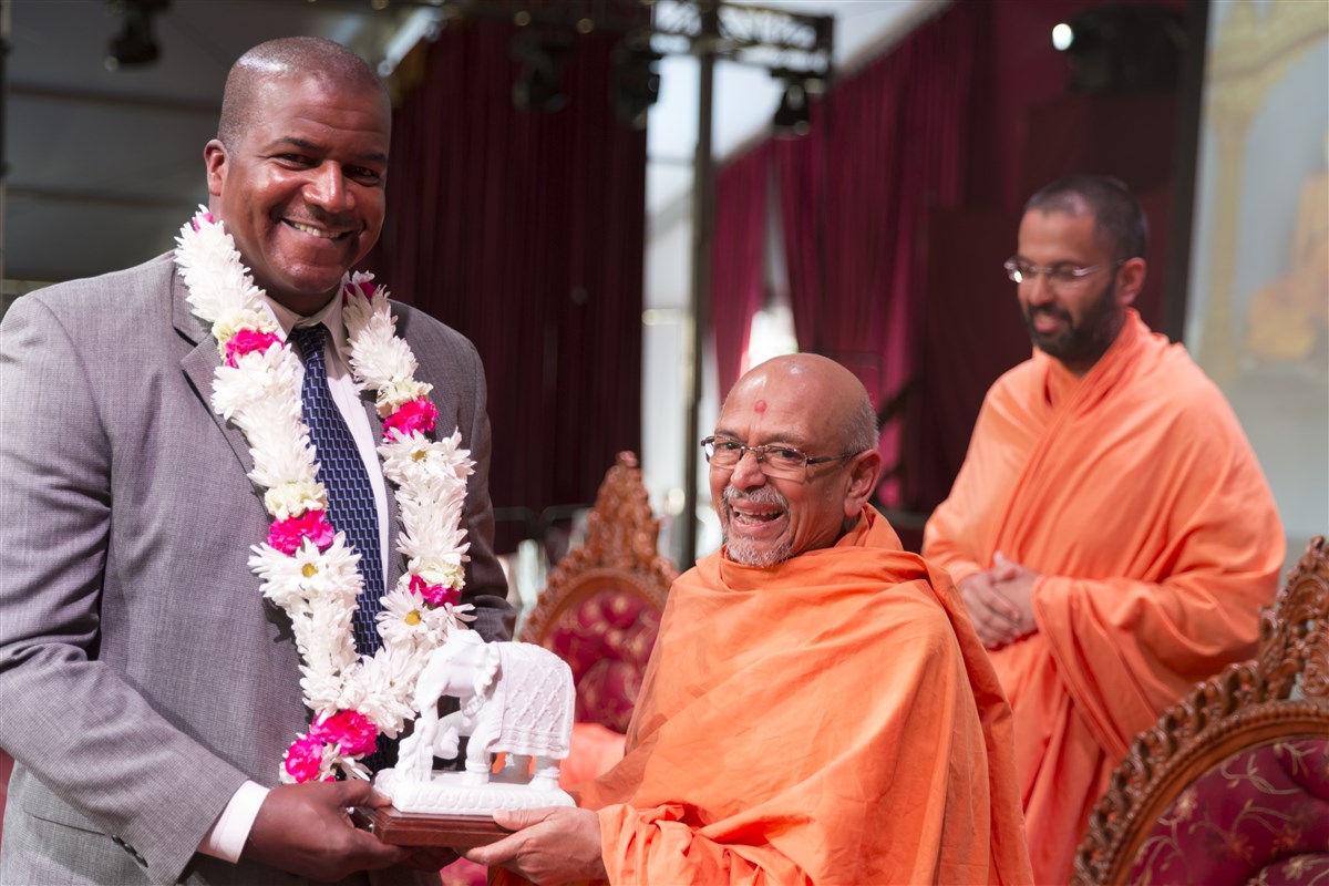 Aaron Ford, special agent in charge of the FBI's Newark Division receives a memento from Pujya Tyagvallabh Swami