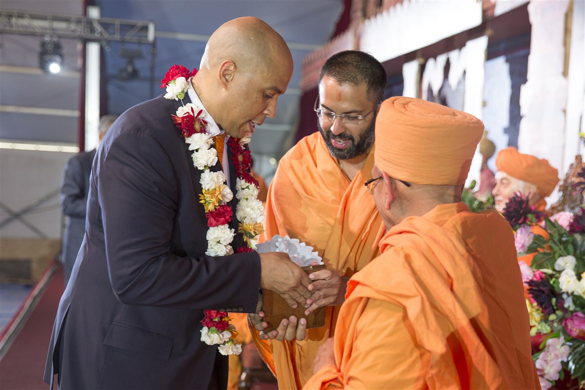 United States Senator from New Jersey, Cory Booker receives a memento from Pujya Tyagvallabh Swami