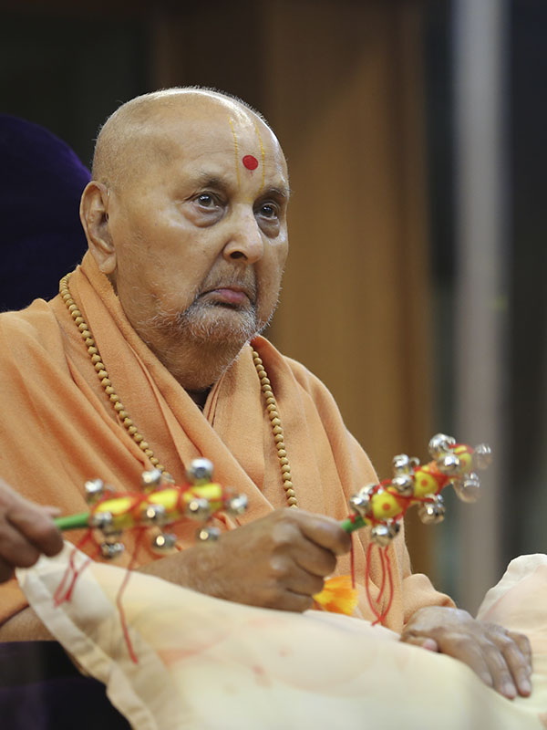 Swamishri plays musical instruments