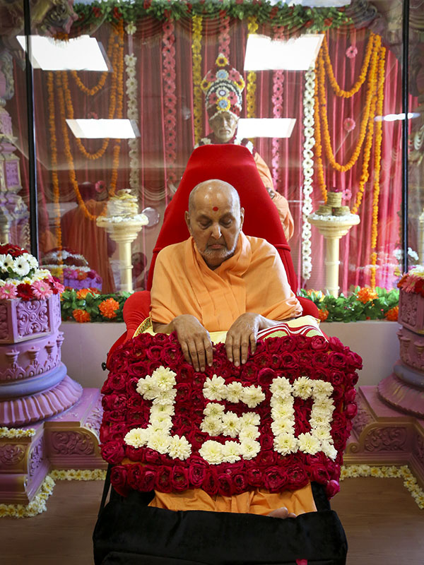 Swamishri is honored with a flower shawl