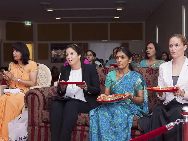 Visitors and devotees perform and participate in arti at the mandir